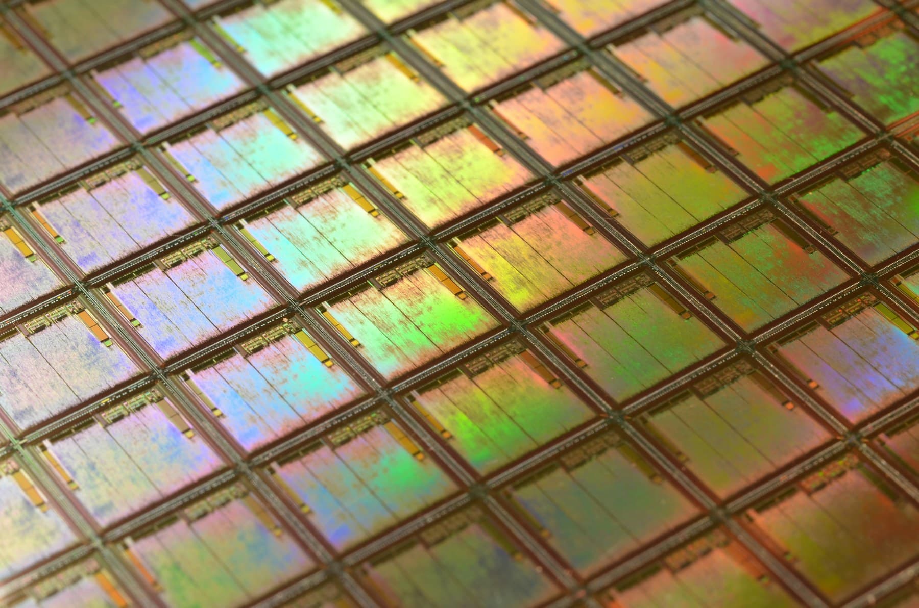 A close grid of silicon dies reflecting a pale spectrum