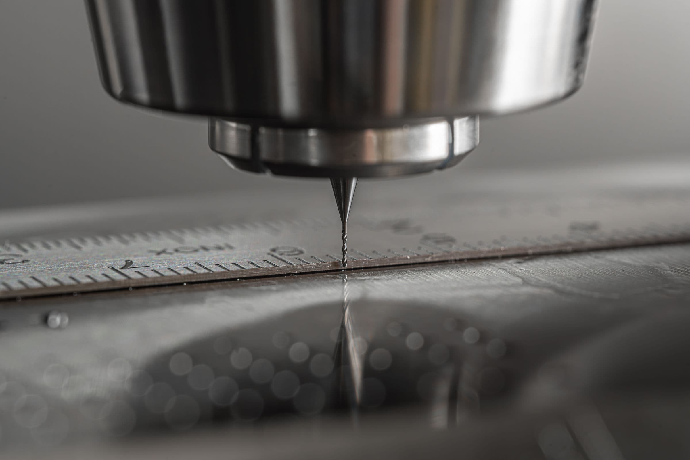 A CNC spindle positioned over a marked metal surface
