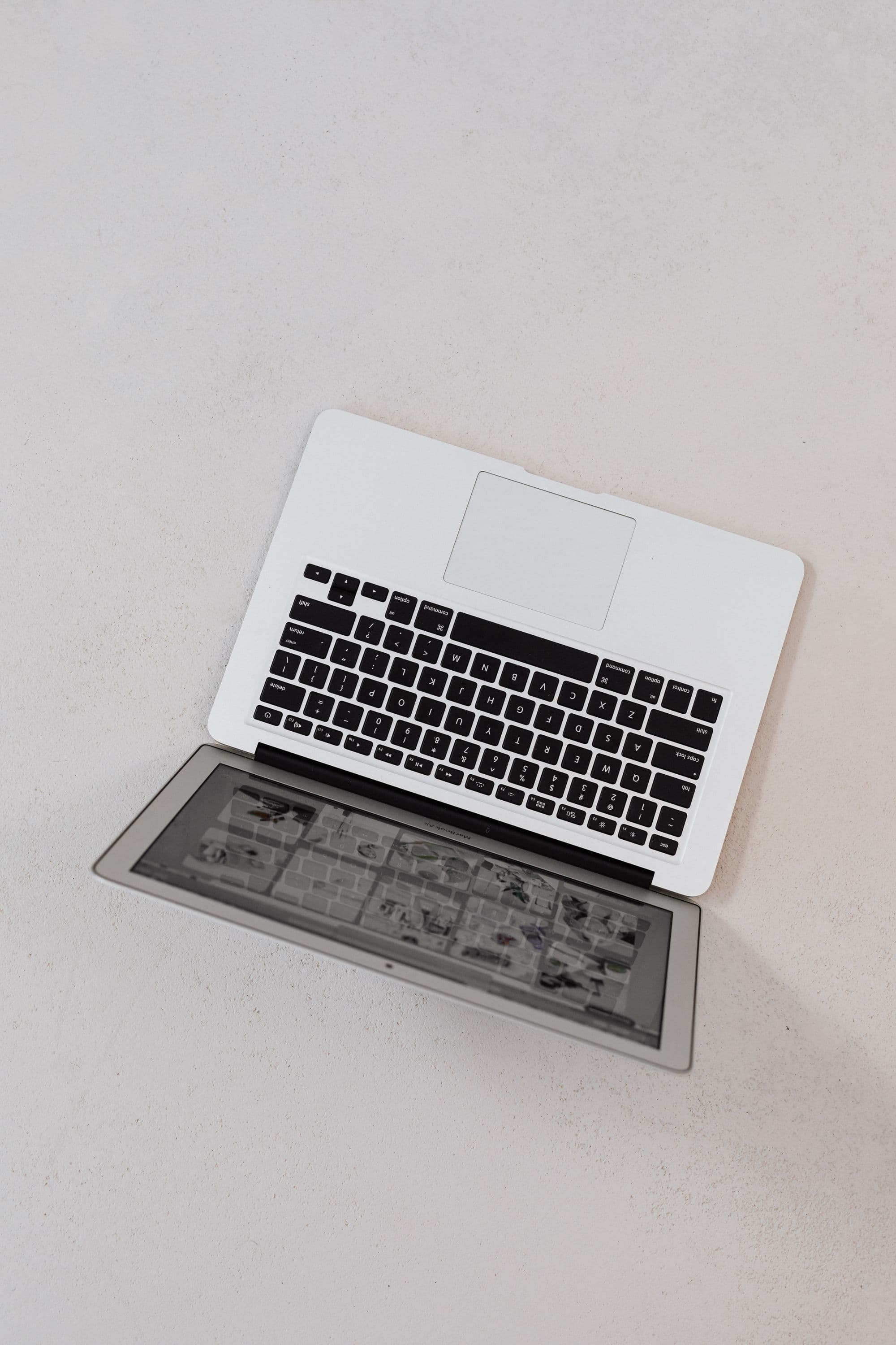 A silver laptop arranged on a white textured surface