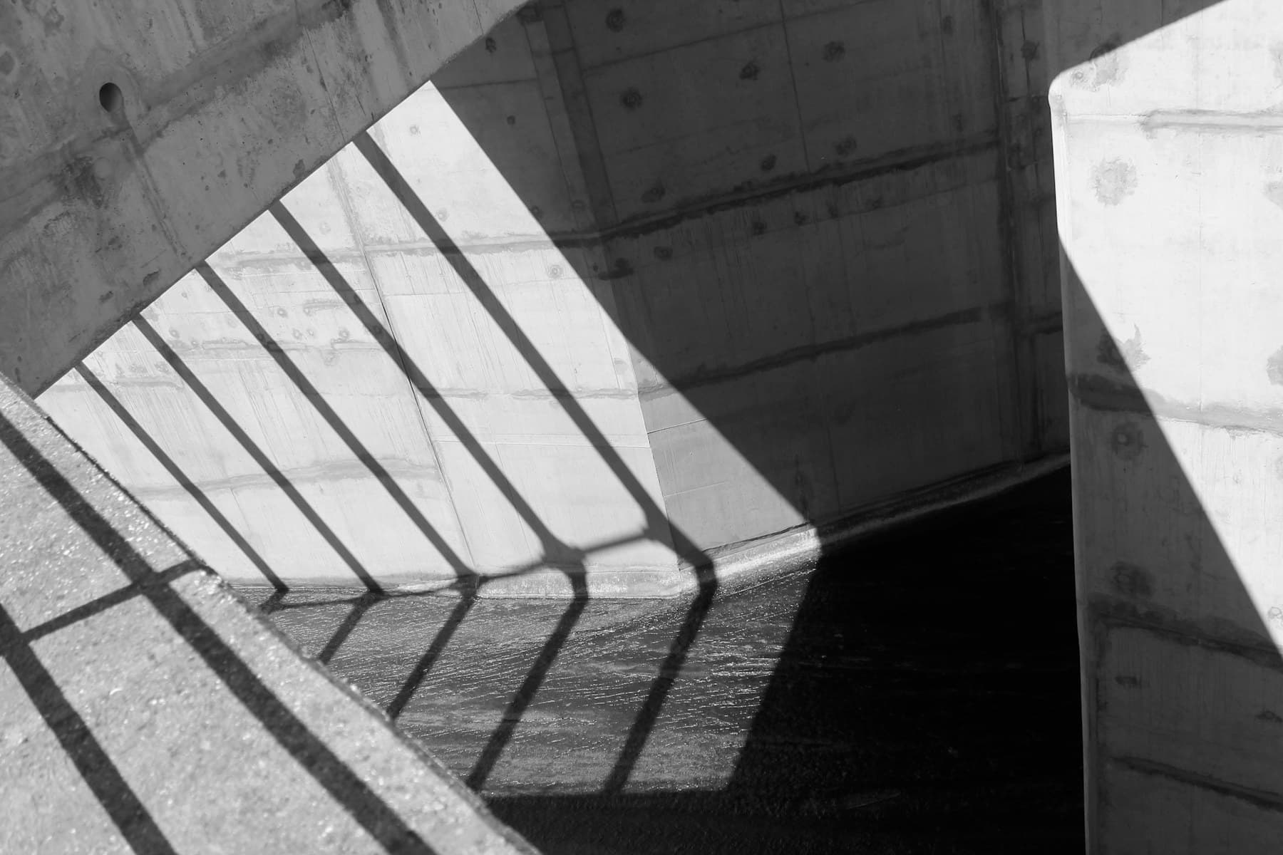 Railing shadows crossing civic concrete