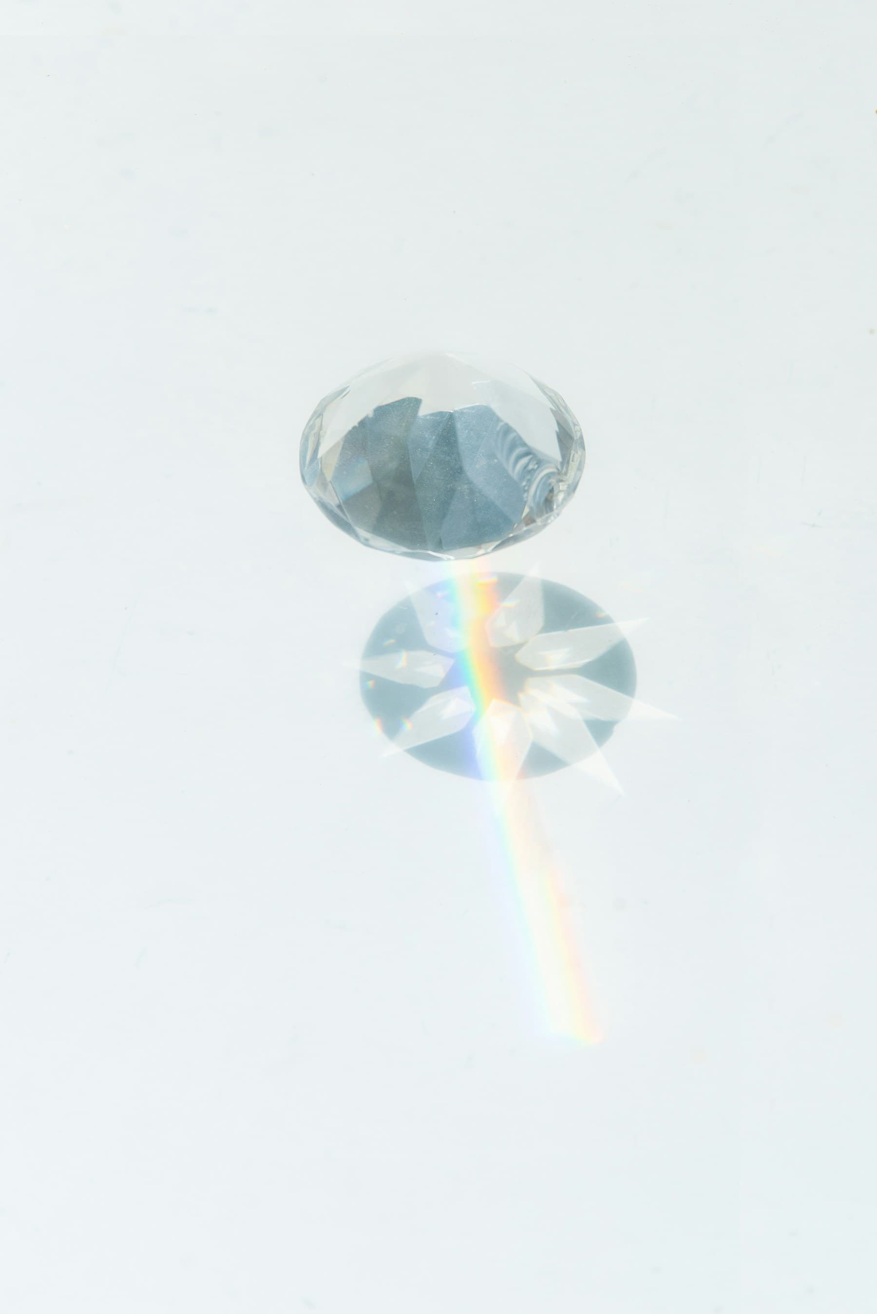 A clear crystal projecting a color spectrum across a white surface