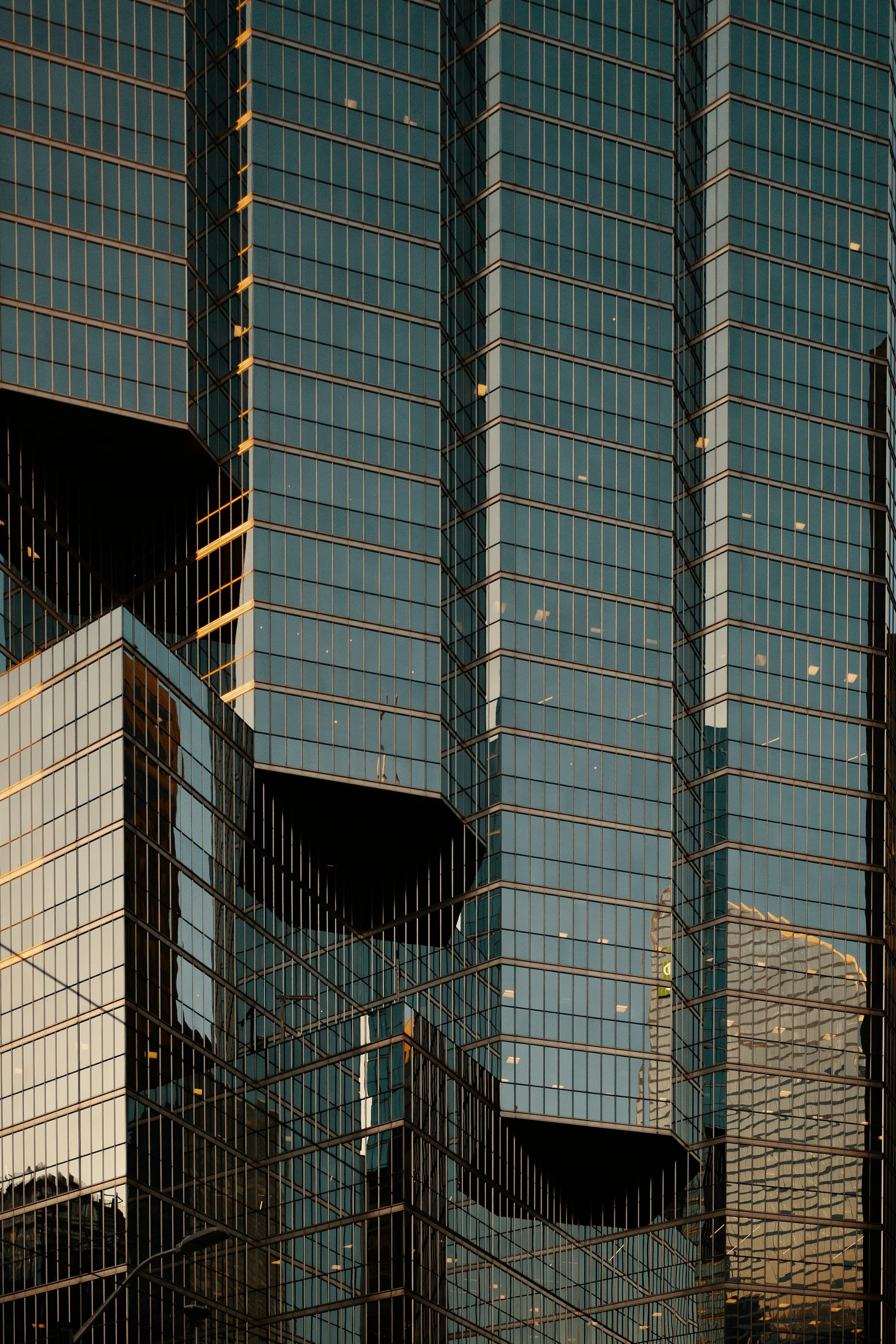 A tall glass business tower reflecting the surrounding city